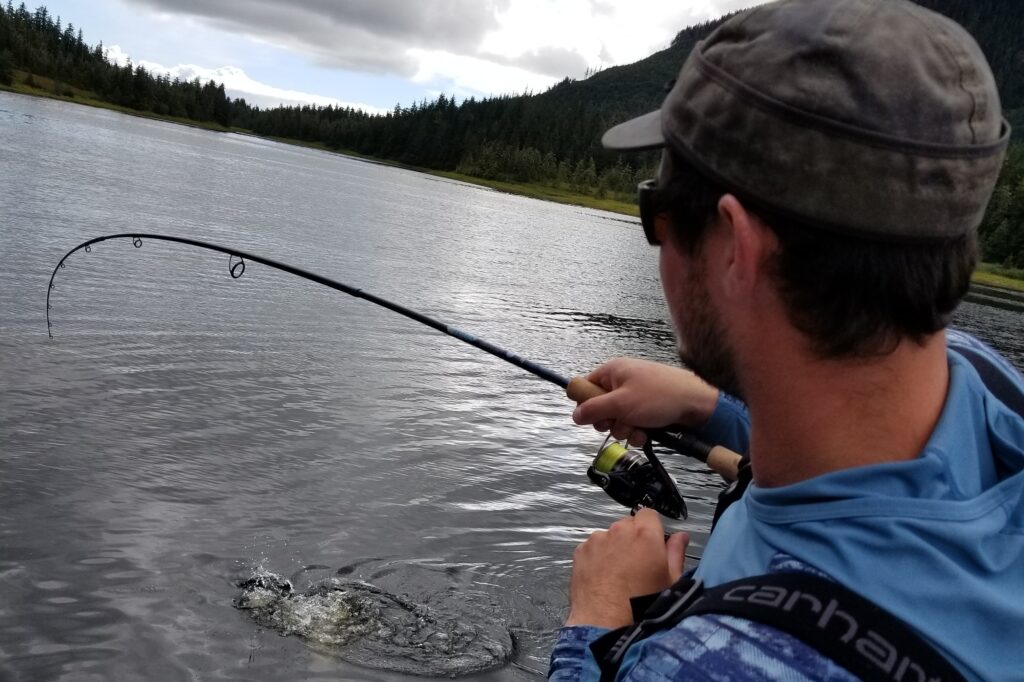 McKeon Roberts (@mckeonhugh) stands on a boat with his fishing pole casted out.