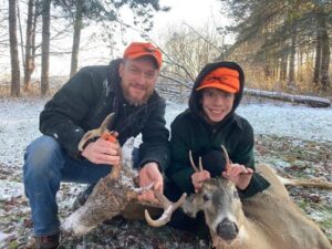 Michael and his son wearing matching Stormy Kromer caps while they smile at their hunted deer.