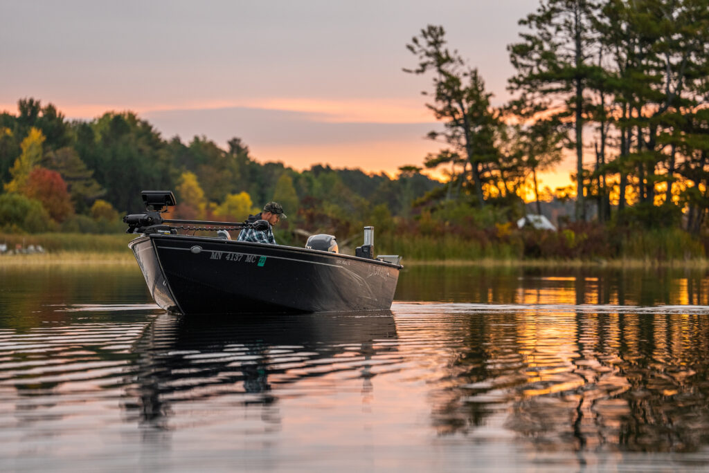 McKeon Roberts (@mckeonhugh) sit on a fishing boat sailing through water surrounded by trees (@wired2fish).