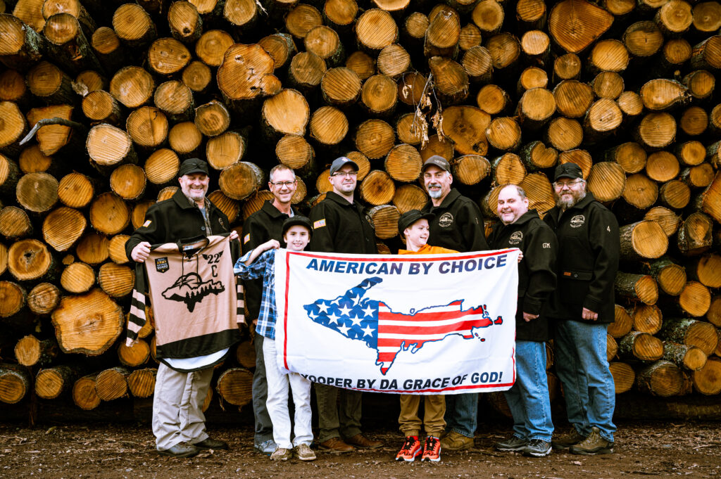 veterans hockey team standing in front of logs