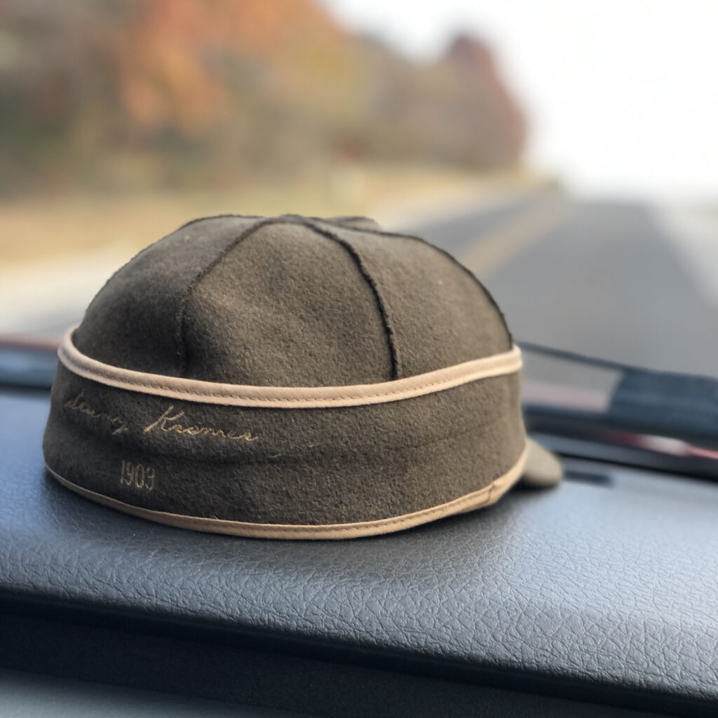 KC Blog The Last Flight Edgar Castillo Stormy Kromer Hat sitting on the dashboard of a car