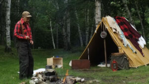 KC Blog Battlefields and Backpacks an old man standing next to a campfire and a tent