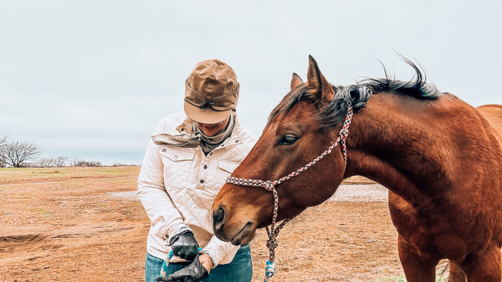 Courtney Lujan wearing a Stormy Kromer hat while standing next to her horse