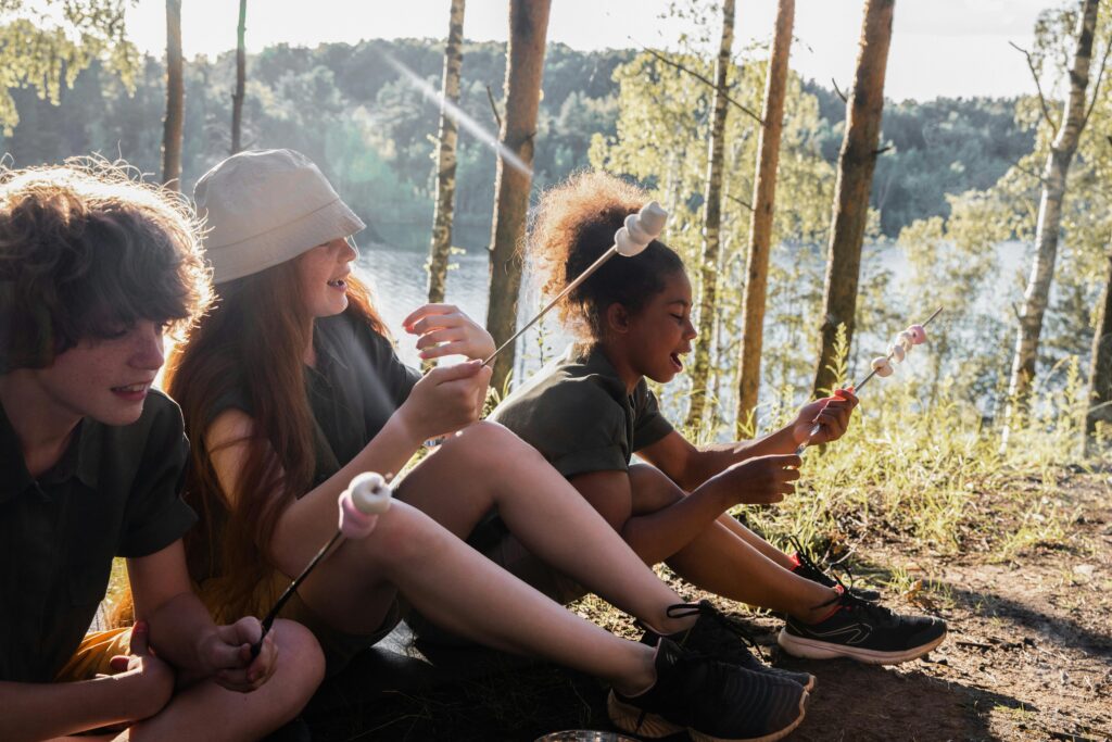 Kids at a campsite, roasting marshmallows on a fire