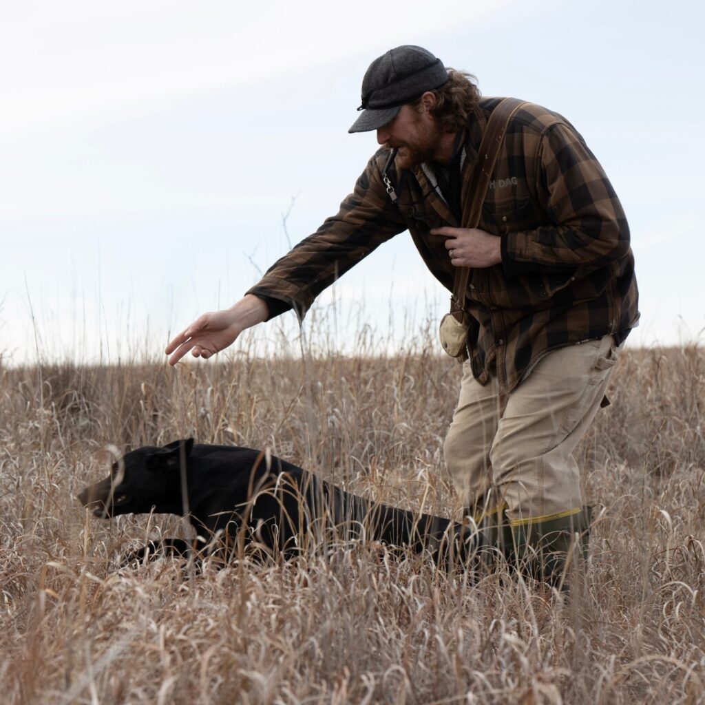 Jeremy Moore signals for his hunting dog to run after prey