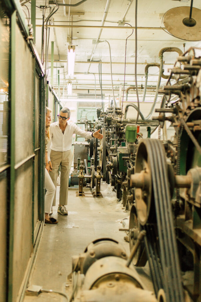 Team members of American Woolen survey the manufacturing floor.